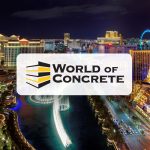 Aerial night view of the Las Vegas Strip, prominently featuring the brightly lit replica of the Eiffel Tower at the Paris Las Vegas Hotel. The bustling street is lined with illuminated hotels and the Bellagio fountain show is visible. Overlaying the image is the 'World of Concrete' logo with stylized black and yellow stripes, suggesting a connection to the construction industry event.