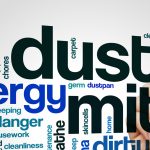 A conceptual word cloud related to dust allergies, with the words 'dust,' 'mite,' 'allergy,' and 'hygiene' in large, bold letters. Surrounding words include 'sneezing,' 'vacuum,' 'housecleaning,' and 'dustpan,' in various sizes and orientations, creating a cluster that conveys themes of cleaning, allergic reactions, and household maintenance.