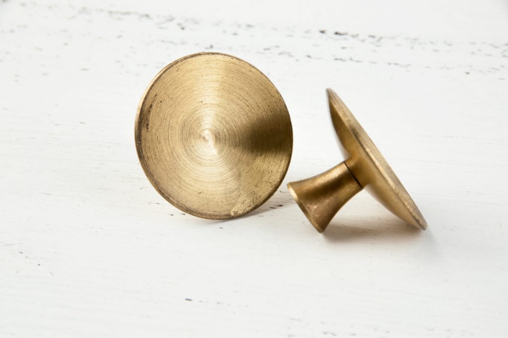 Two brass knobs which could be used for an epoxy pulley test.