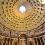 Interior view of the Pantheon's famous coffered concrete dome with a central opening (oculus), showcasing the geometric architectural details and the natural light streaming in, illuminating the ancient Roman temple.