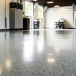 Bright garage interior with polished epoxy floor coating, storage cabinets, and natural light from large open doors