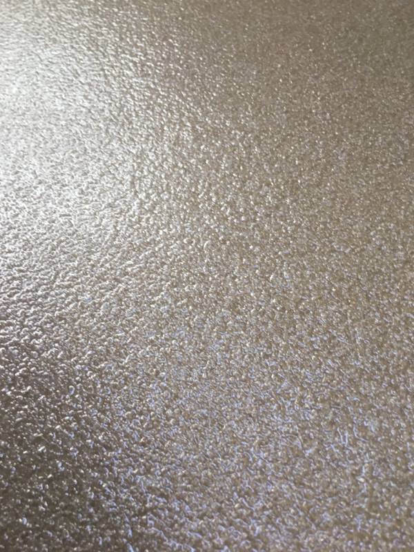 Close-up of a textured epoxy floor with a mottled appearance, showcasing shades of gray with a subtle glossy sheen reflecting ambient light.