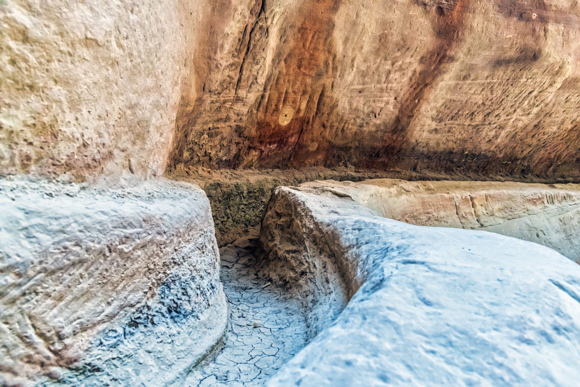 An ancient, eroded stone staircase carved into a rock face, showcasing the weathered steps and striations on the surrounding rock surface, indicative of historical architecture or old ruins.